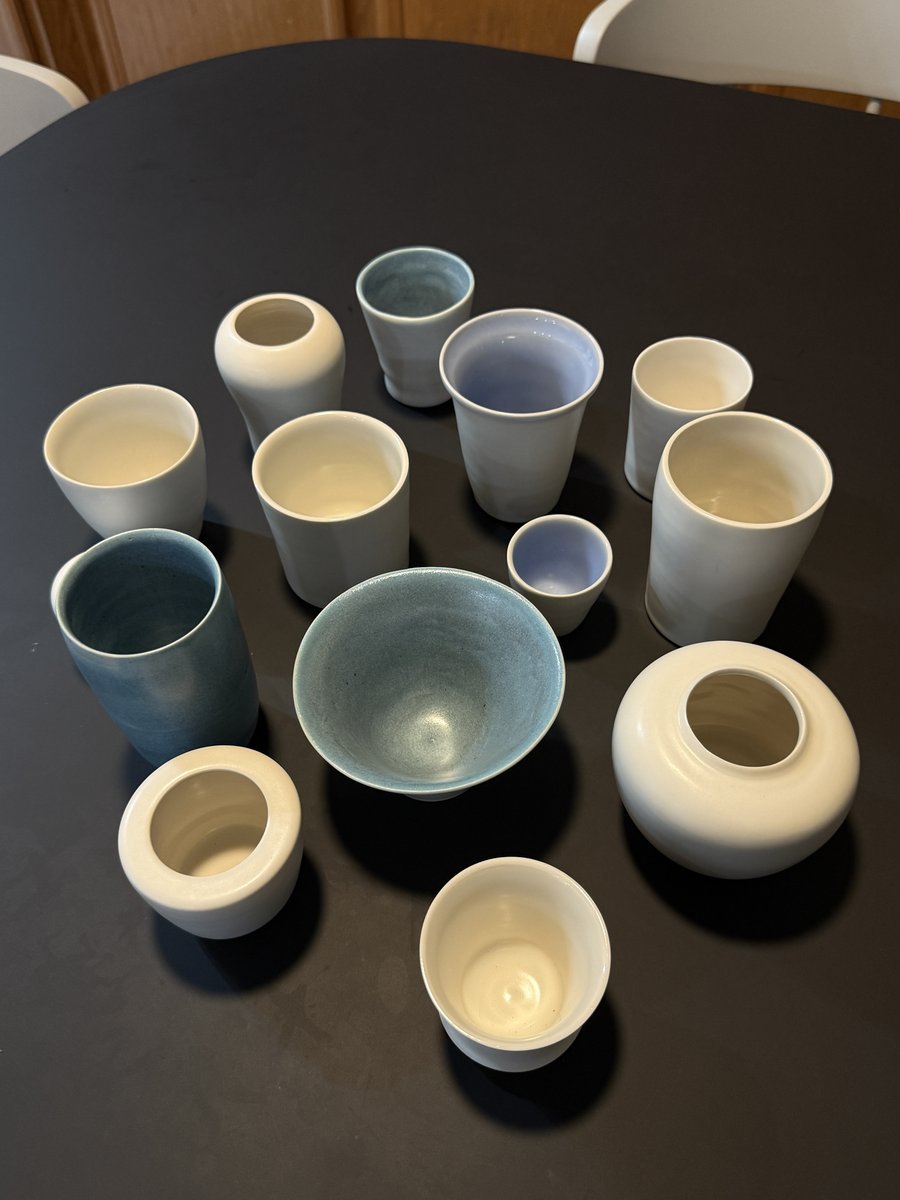 Glazed cups and vases from above on a dark table