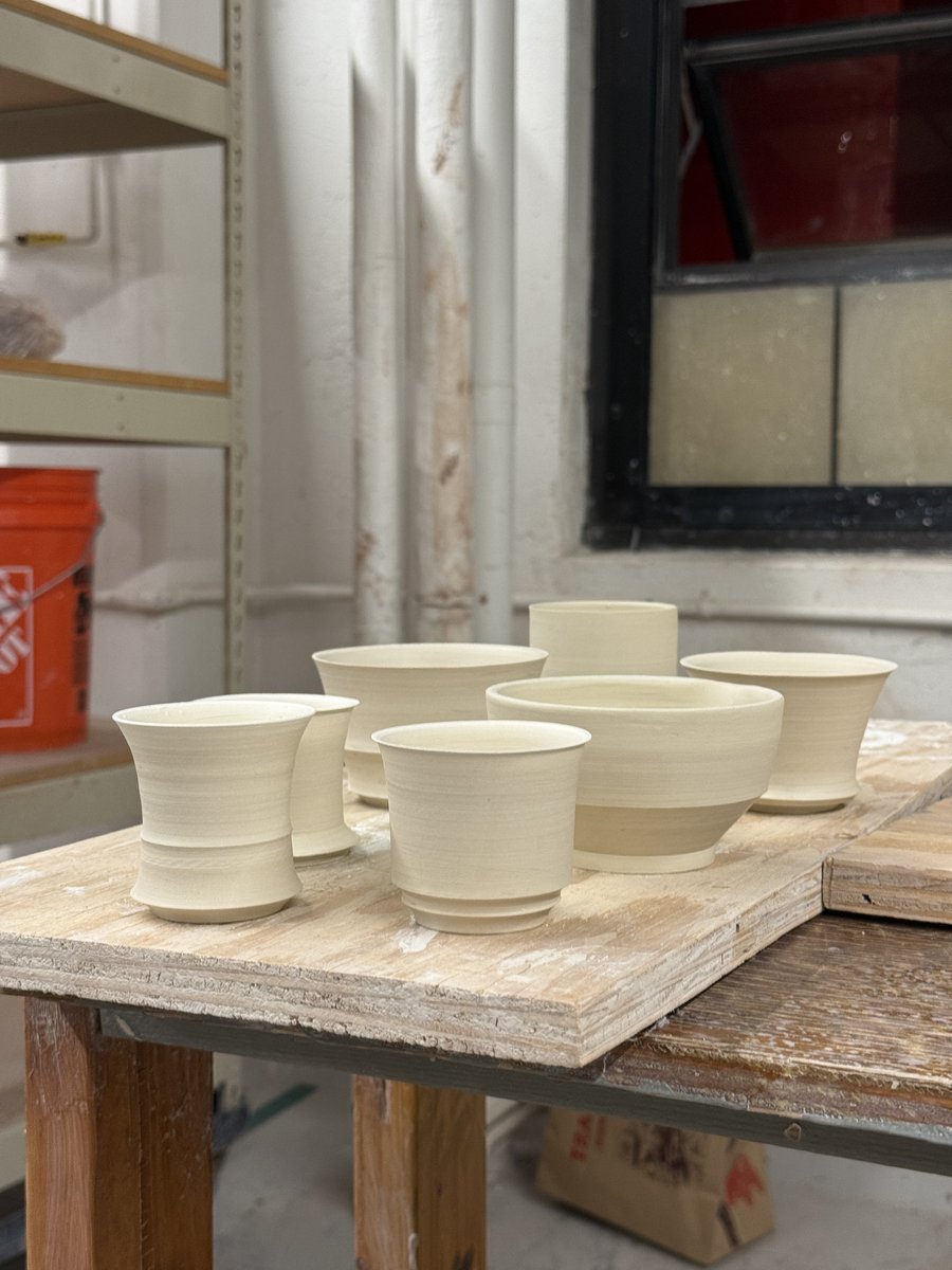 Greenware cups and bowls drying on a studio board