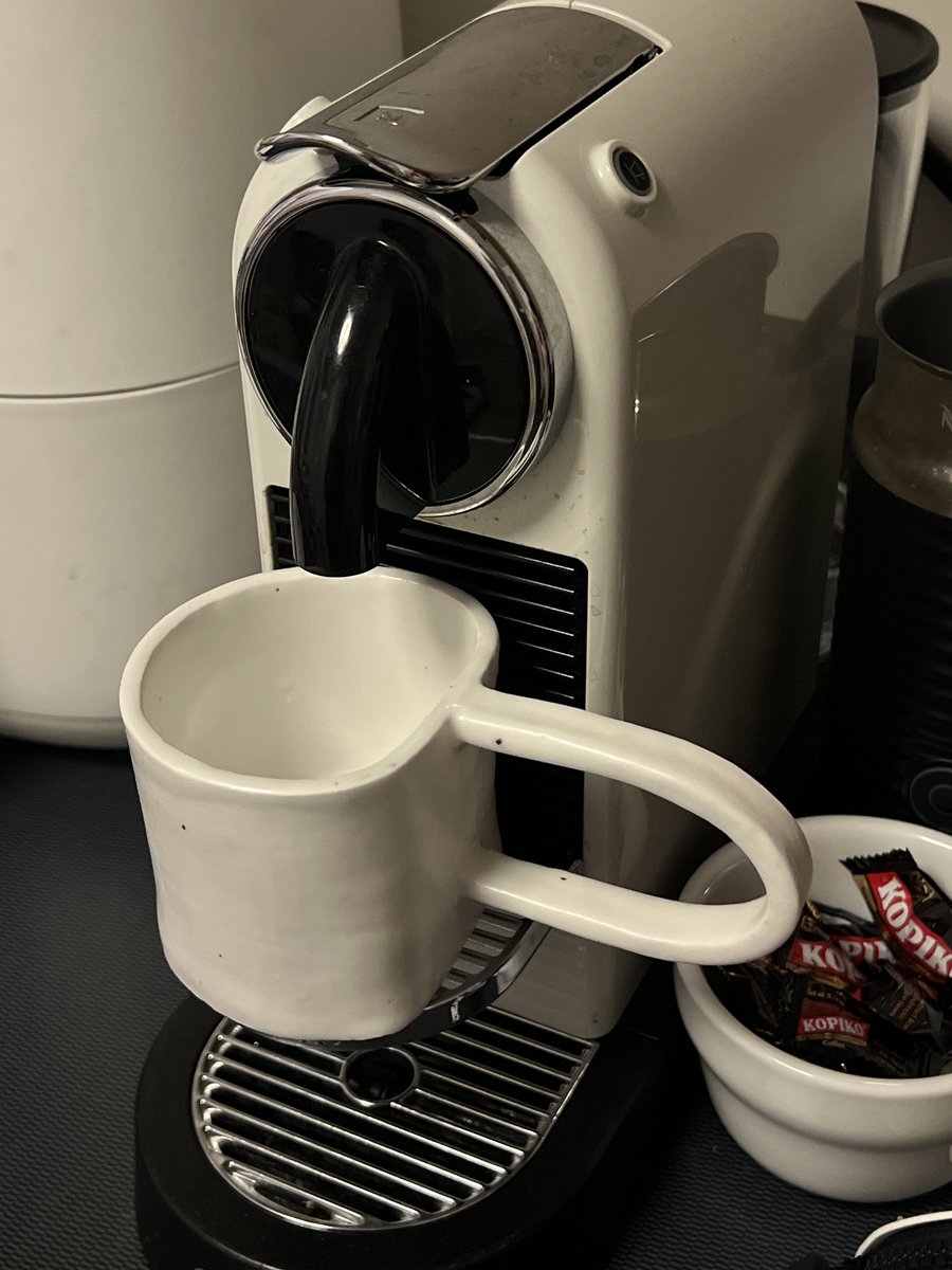 Handbuilt mug with a loop handle under an espresso machine